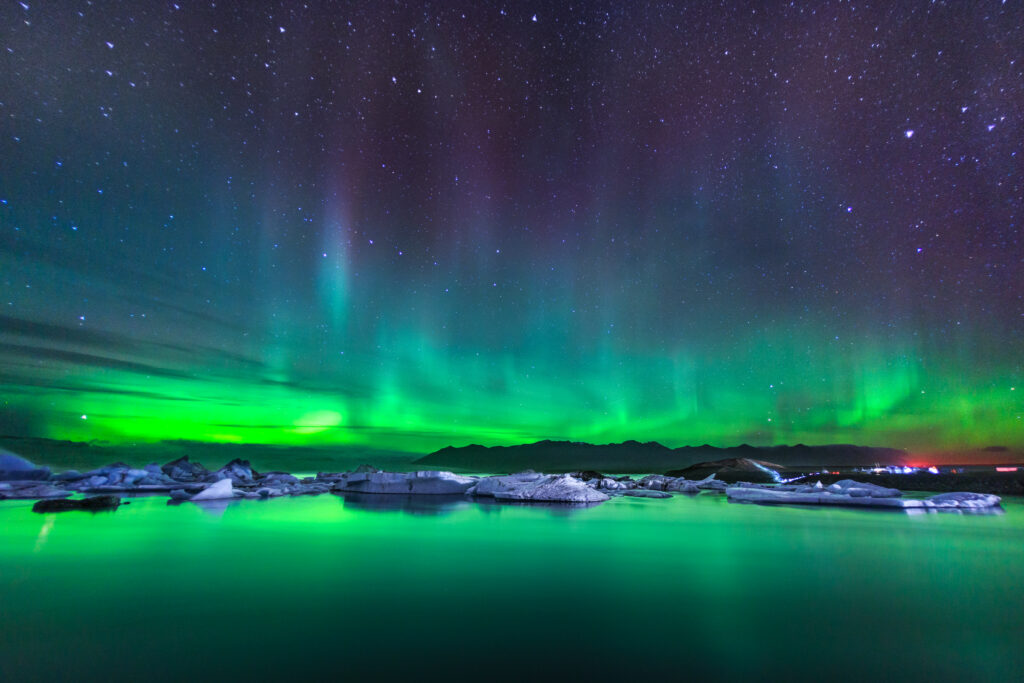 Glacial Lagoon. On a recent trip to Iceland, the author took this photograph of the northern lights dancing over an iceberg-filled glacial lagoon. Ultrawide lenses, like the Canon 15mm fisheye used for this shot, allow one to capture dramatic swaths of sky while still including an interesting foreground. A Canon EOS 6D DSLR camera was used for this 13-second exposure at ISO 1600 with the lens fully open at f/2.8.